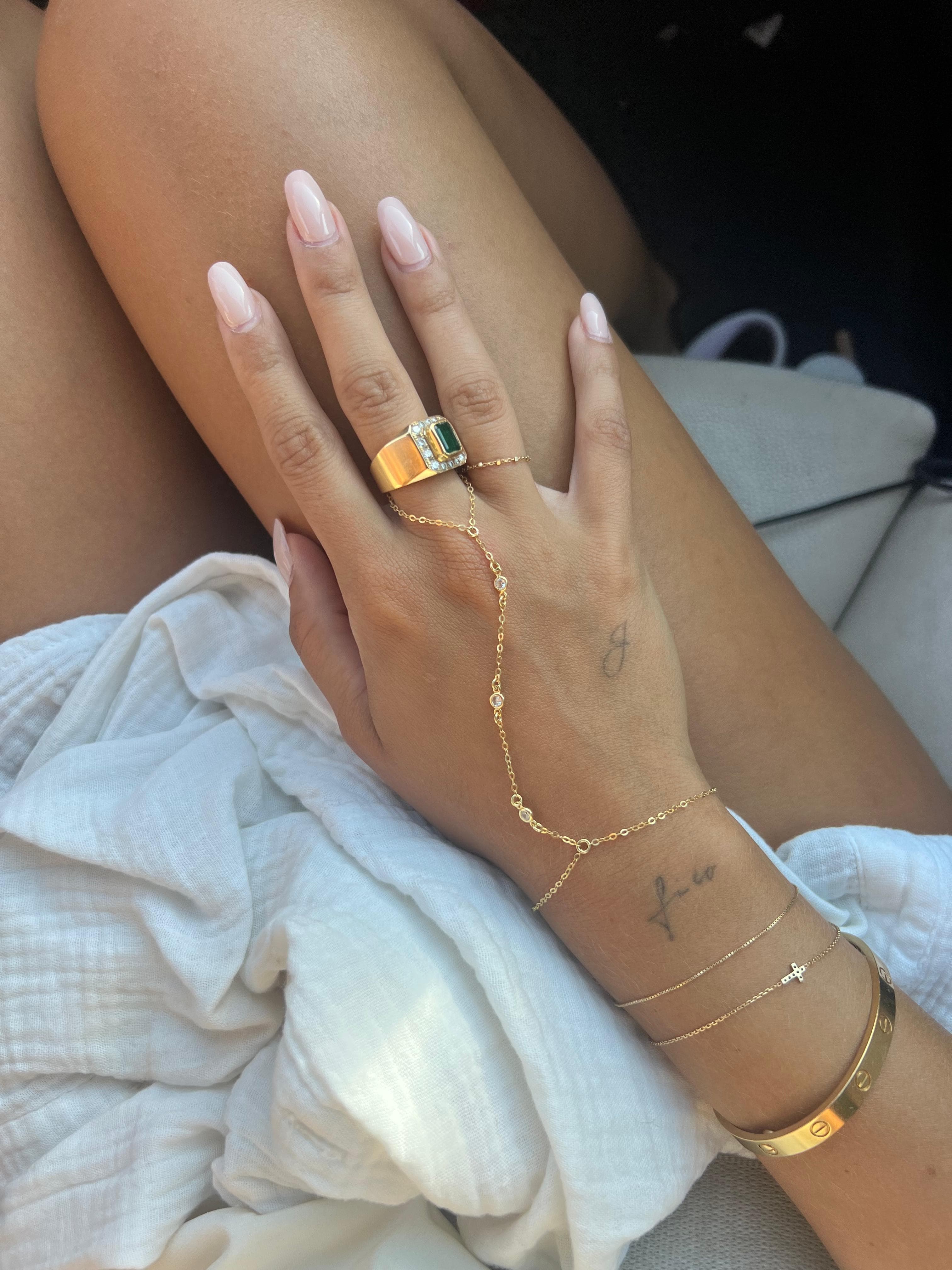 Close-up of a hand wearing a delicate gold chain