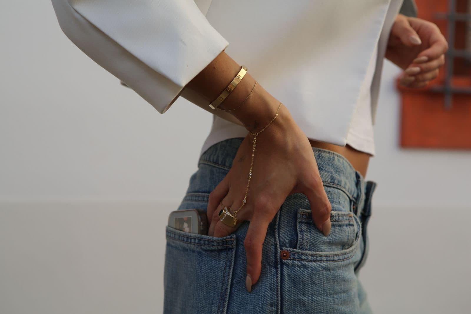 Hand chain worn with white blazer and denim