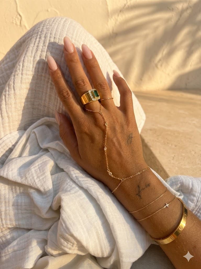 Close-up of a gold hand chain on skin in warm light